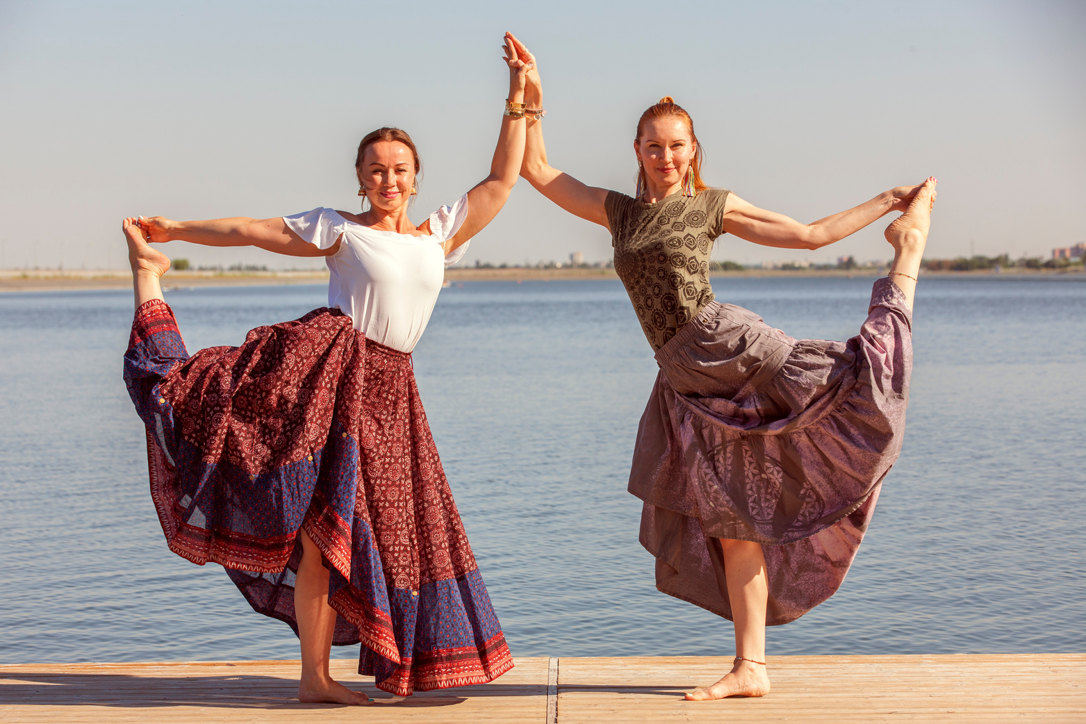 Two mature women keeping fit by doing yoga in the summer