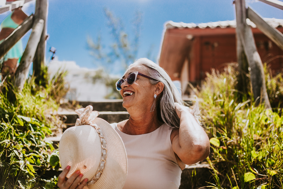 A Happy Elderly Woman Wearing Sunglasses with Sunhat