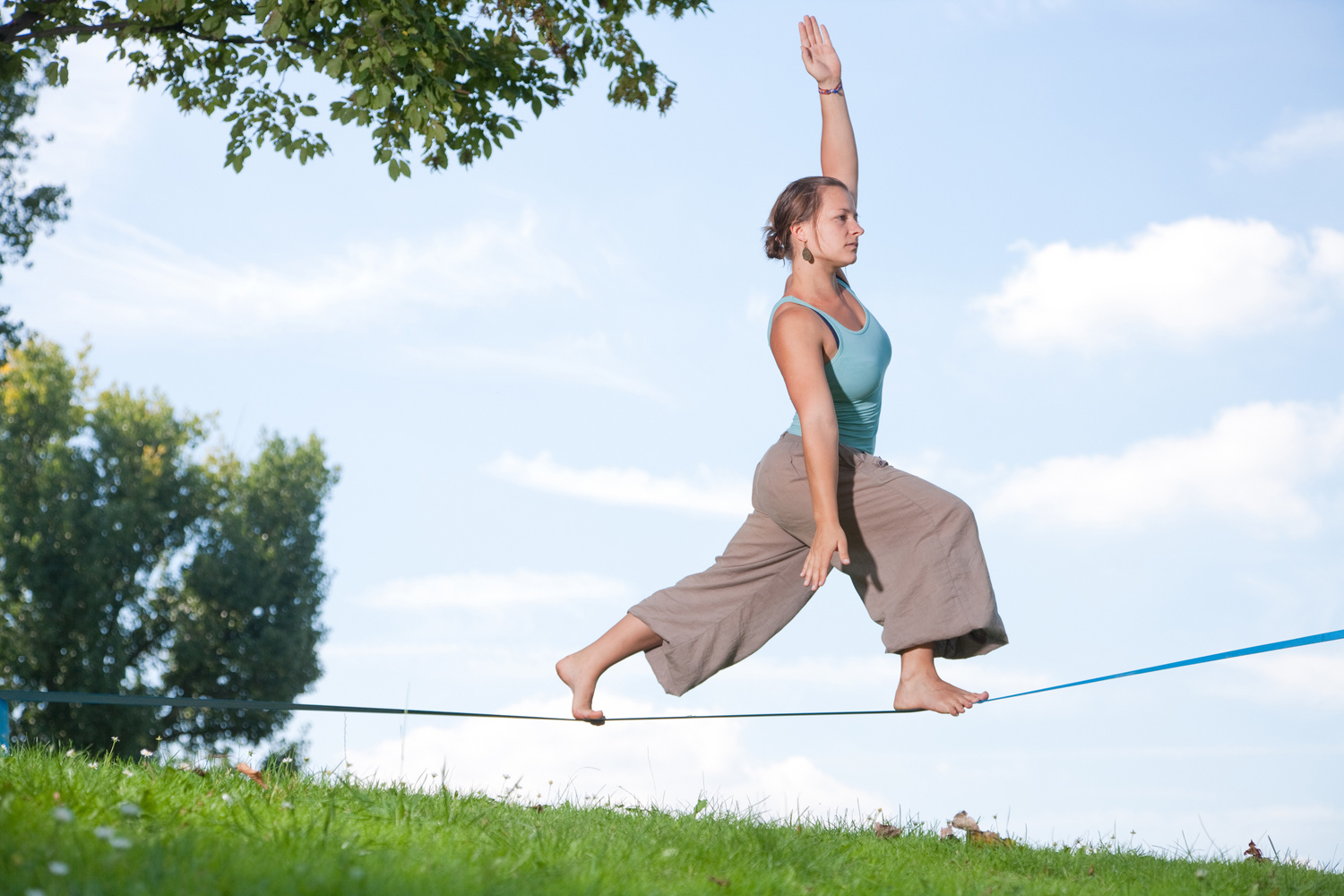 A woman in the park walking on a tight rope